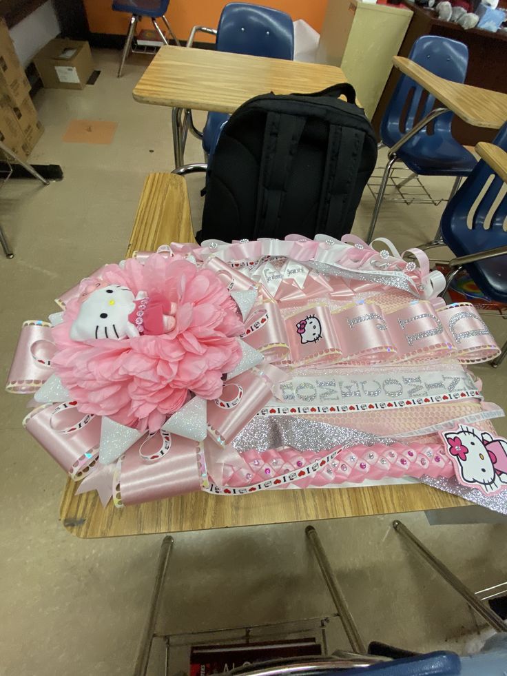 there is a hello kitty cake on the table in front of some school desks