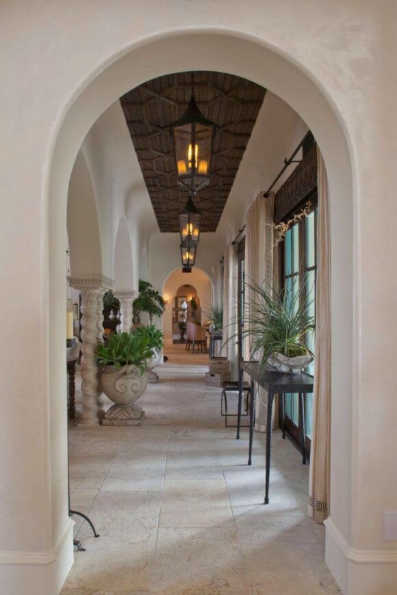 an archway leading to a living room with potted plants on either side of it