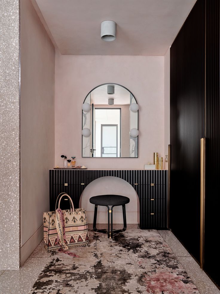 a black and white bathroom with a round mirror above the sink, rug on the floor