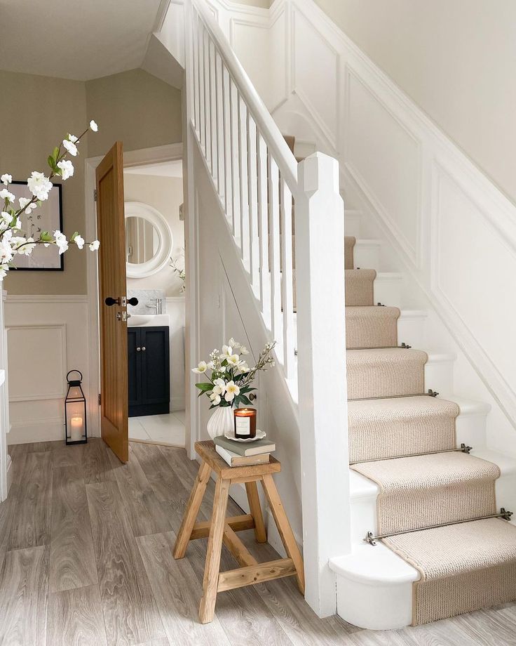 there is a vase with flowers on the table next to the stairs