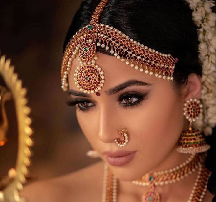 a woman wearing an elaborate head piece and jewelry