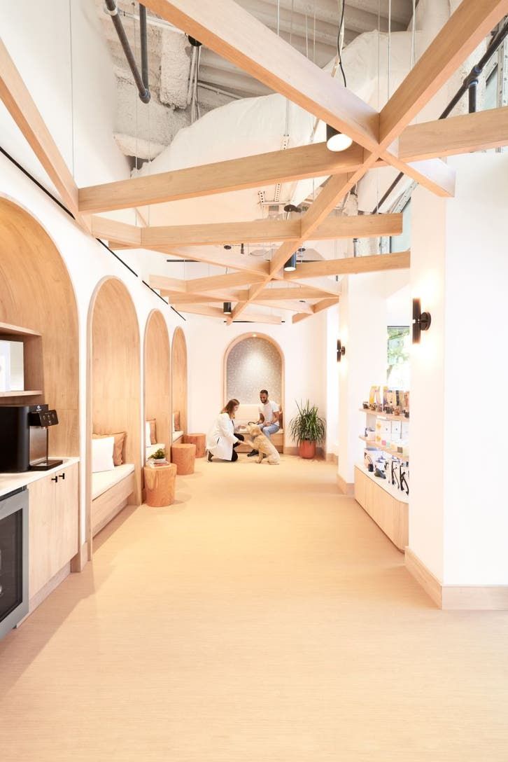 a man is sitting in the middle of a room with wood beams on the ceiling