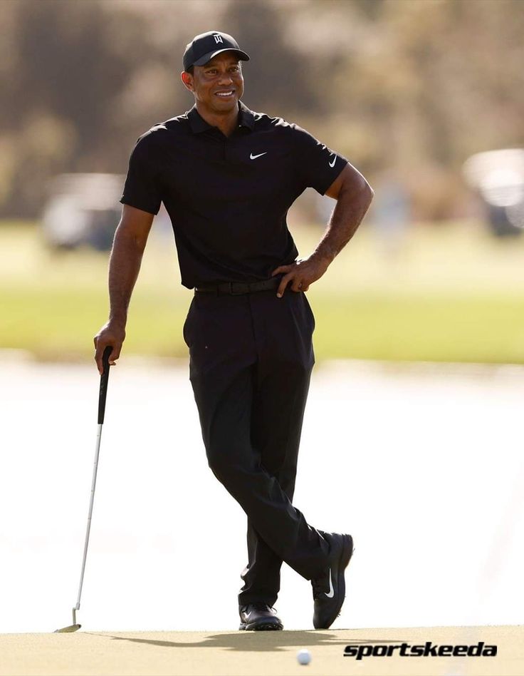 a man in black shirt and hat playing golf