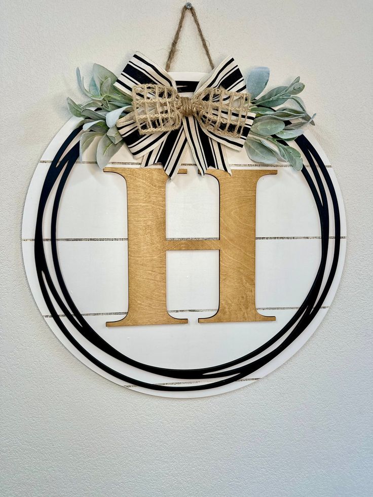 the letter h is made out of wood and decorated with greenery