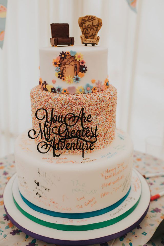 there is a three layer cake that has confetti on the top and writing on the bottom