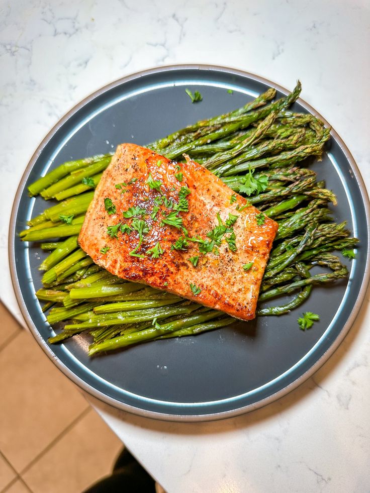 a piece of salmon and asparagus on a plate