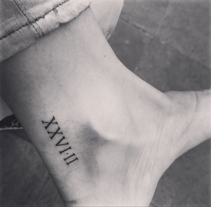 a woman's foot with roman numerals tattoo on her left side ankle