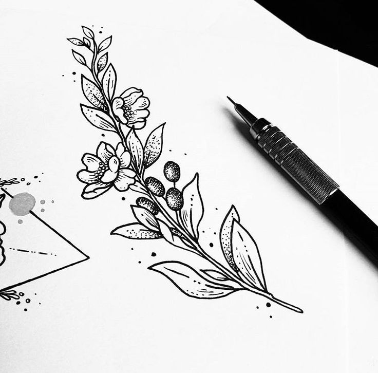 a black and white drawing of flowers on paper with a pen next to it,