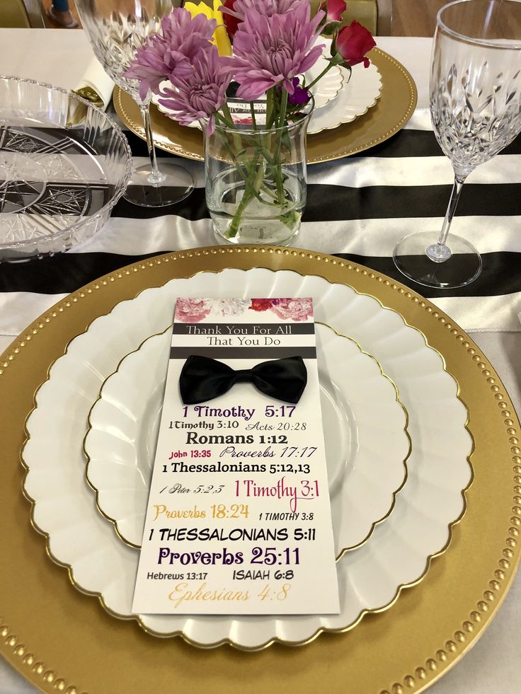 a place setting with flowers and wine glasses on the table for an elegant dinner party