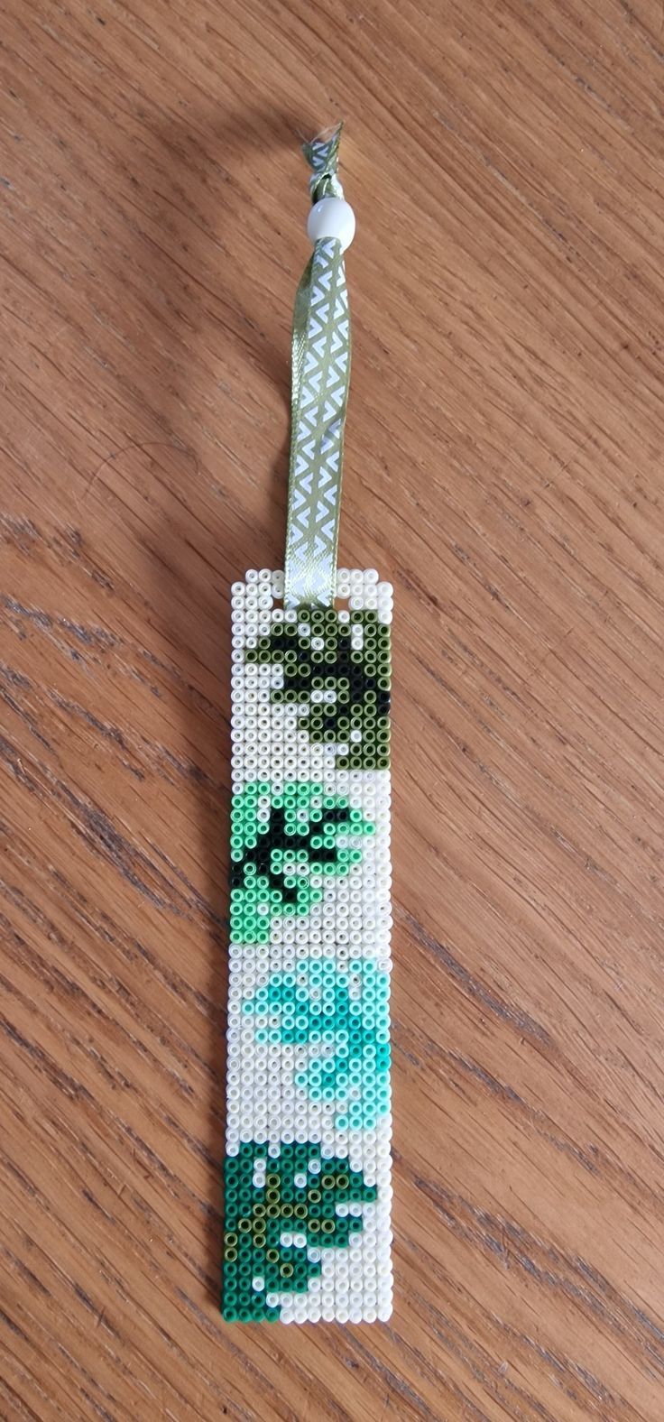 a small beaded bookmark on a wooden table