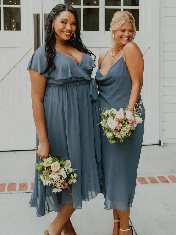 two women standing next to each other wearing dresses and holding bouquets in their hands