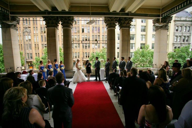 a bride and groom are walking down the red carpeted aisle to their wedding ceremony