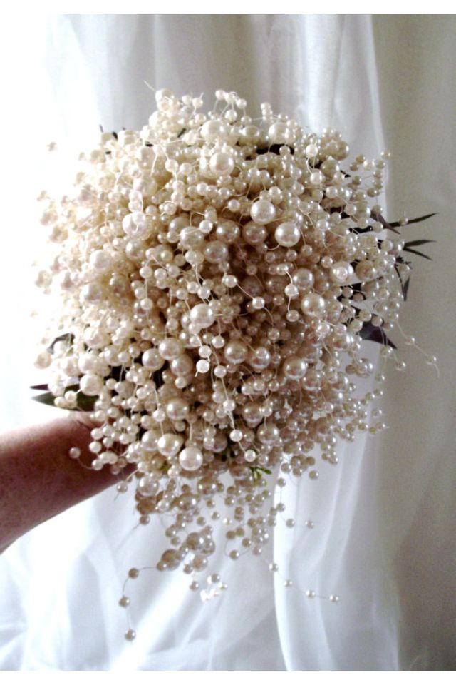 a bouquet of white flowers with pearls on it