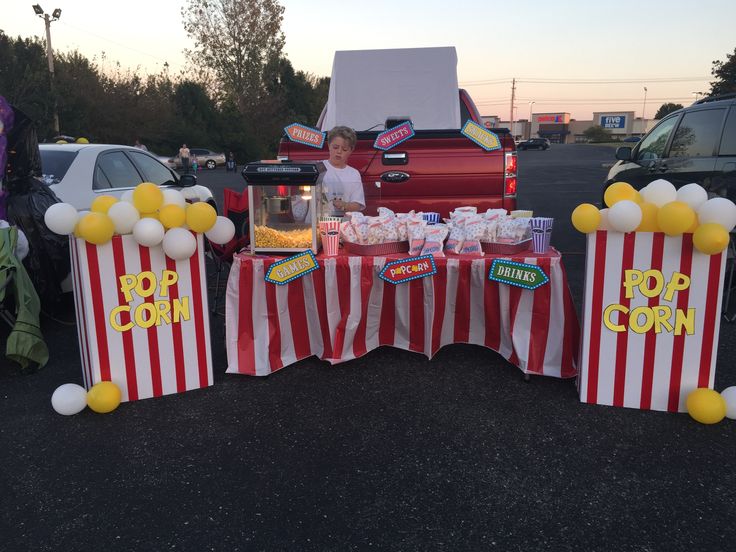 two red and white striped bags with popcorn on them sitting in the middle of a parking lot