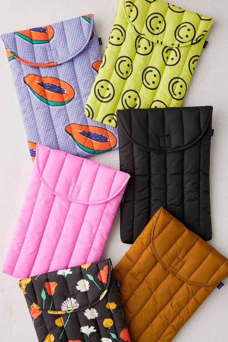 four sleeping bags lined up next to each other on top of a white surface,