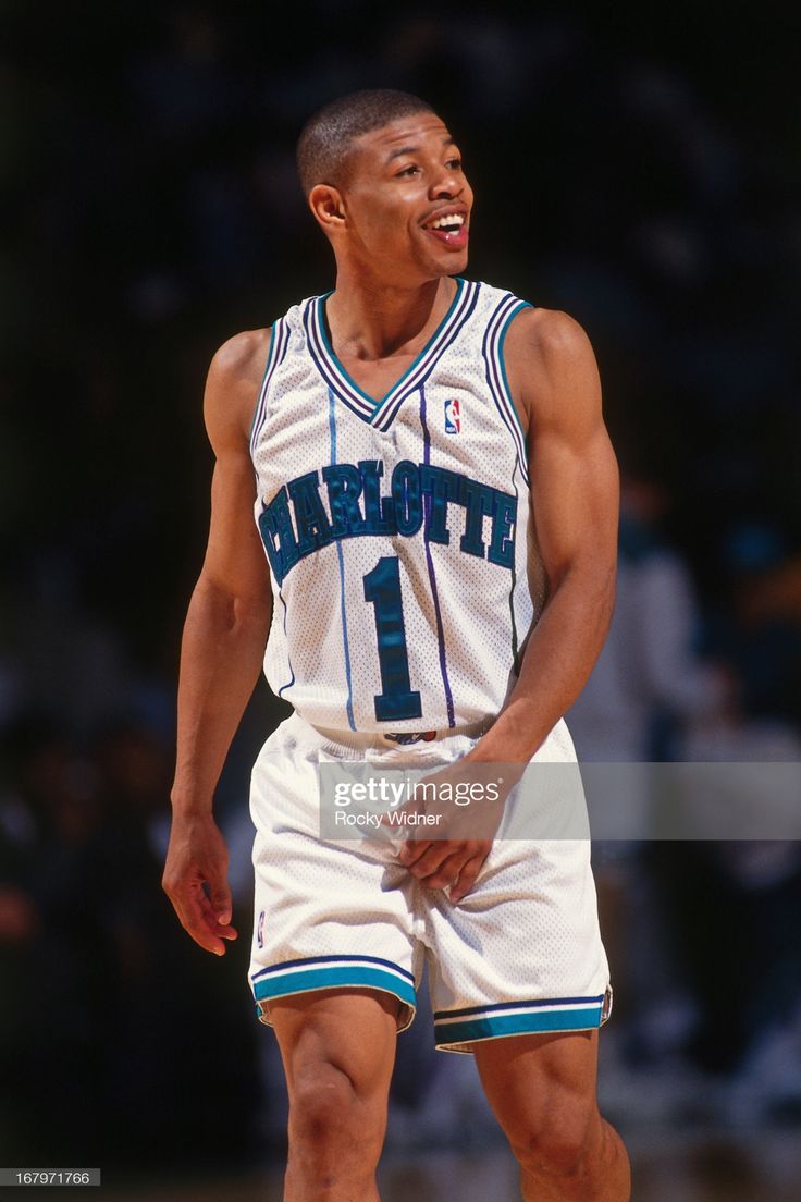 a basketball player standing on the court with his hands in his pockets and looking up