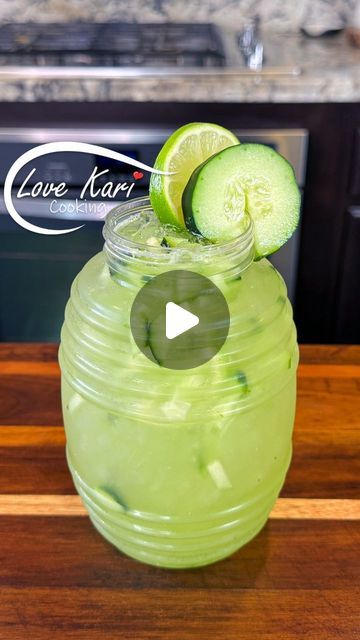 a green drink with cucumbers on the rim