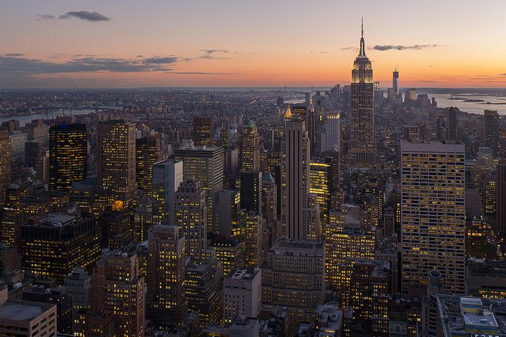 an aerial view of new york city at night with the empire building in the foreground