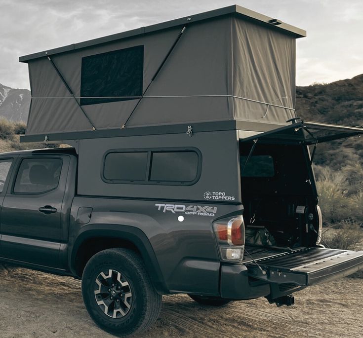 the truck is parked in the desert with its roof tent on it's back