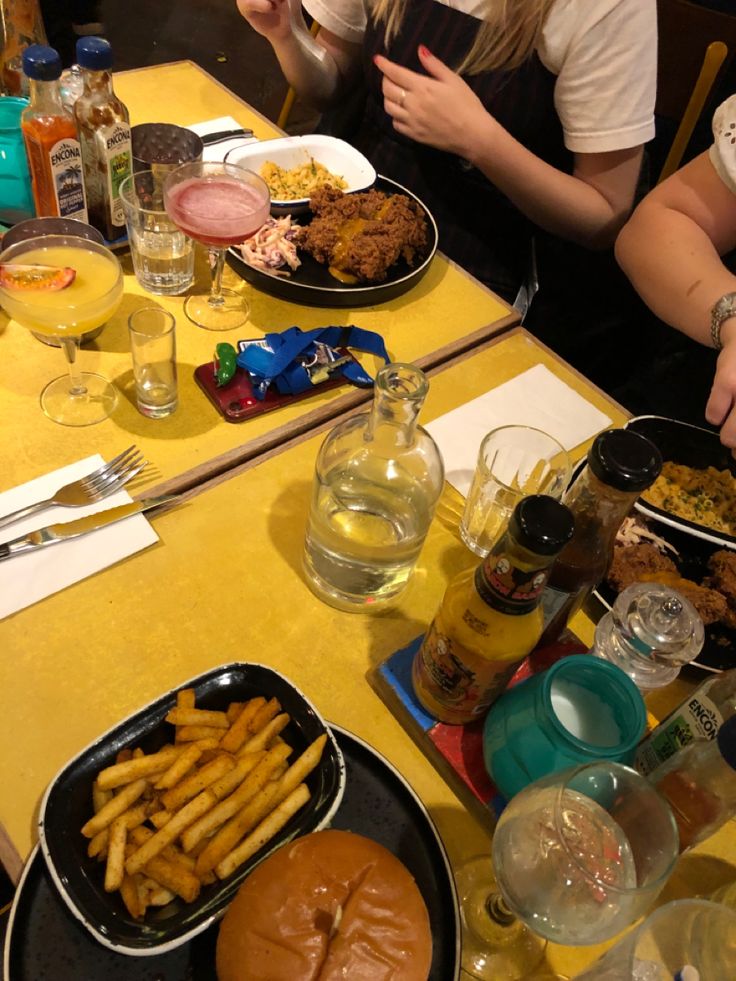 two people sitting at a table with plates of food