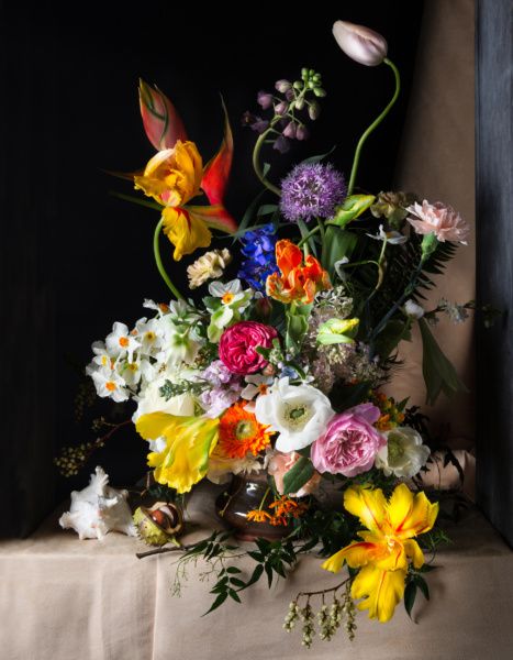 a vase filled with lots of different colored flowers