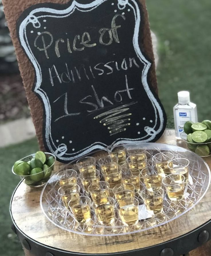 there is a sign that says price of whiskey on the table with glasses and bottles