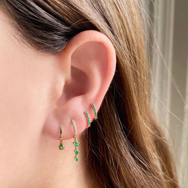 Crafted with gorgeous green Emeralds, these Mini Huggies add the perfect pop of color to any ear story. Available in 14k Yellow Gold Each earring features 7 Emeralds totaling .04 carats 10mm Diameter Sold Individually or as a Pair Green Dangle Hoop Earrings For Anniversary, Fine Jewelry May Birthstone Huggie Earrings, May Birthstone Huggie Earrings In Fine Jewelry Style, Green Round Huggie Earrings For Pierced Ears, May Birthstone Huggie Earrings Fine Jewelry, Fine Green Dangle Jewelry, Green Diamond Pierced Earrings, Green Diamond Drop Earrings With Prong Setting, Dainty Green Huggie Jewelry