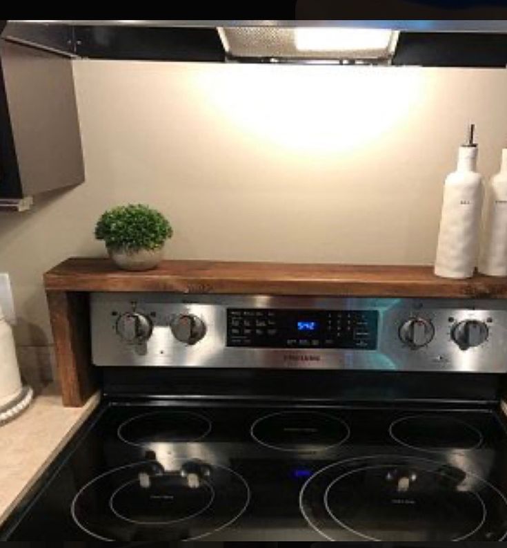 a stove top oven sitting inside of a kitchen next to a white wall and green border