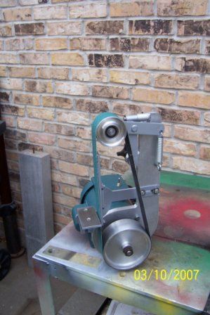 a metal object sitting on top of a table next to a brick wall and floor