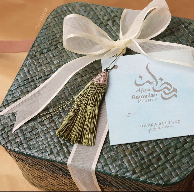 a gift wrapped in wicker with a white ribbon and tag attached to the top