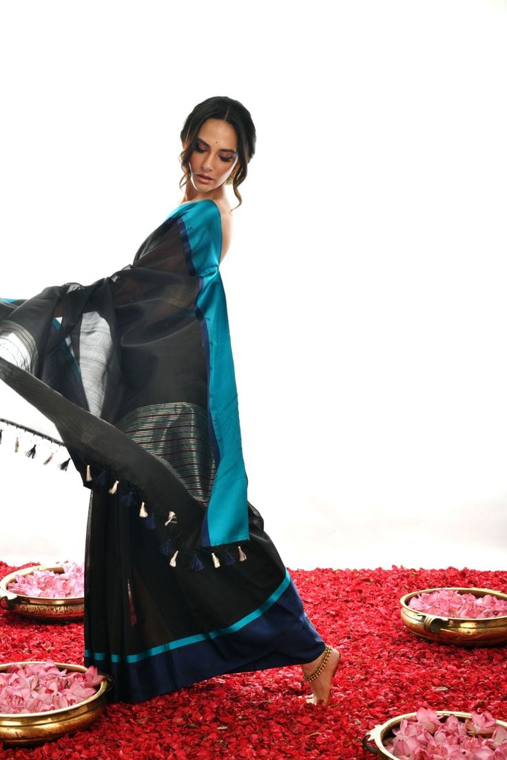 Crafted with care and expertise, this Handwoven Pure black Soft cotton by Kora Banarasi saree offers a unique look. Boasting a striking blue mashru silk border and a luxurious black color, this saree exudes a classy, elegant feel. Experience elegance and comfort like never before. Black Traditional Wear With Zari Weaving For Designer Wear, Black Traditional Wear With Zari Weaving For Designer Occasions, Diwali Black Tussar Silk Saree, Black Silk Saree For Festive Occasions, Festive Black Silk Saree, Designer Black Tussar Silk Saree, Black Tussar Silk Traditional Wear, Black Tussar Silk Traditional Wear With Traditional Drape, Black Katan Silk Saree With Cutdana