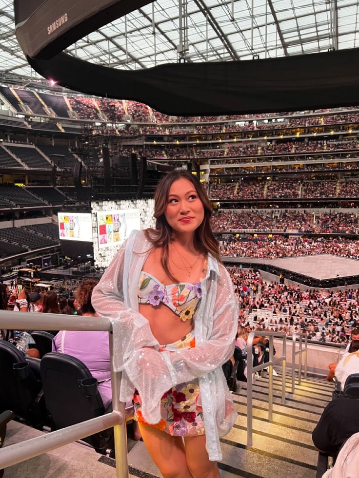 a woman standing in the stands at a sporting event