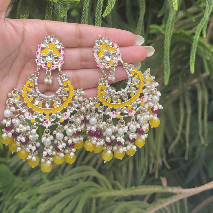 The Yellow Nishuna Earrings are stunning Earrings with Kundan and Gold Plating with Yellow meenakari and Beads. Specifications Materials used: Gold-Plating, Kundan, Yellow and red Beads At Romikas, we pride ourselves on the craftsmanship and high quality of our jewelry, designed to enhance your natural beauty. Please contact us with any questions. Yellow Meenakari Jewelry For Wedding, Yellow Meenakari Chandbali Earrings, Festive Yellow Meenakari Jhumkas, Round Kundan Meenakari Earrings, Festive Yellow Meenakari Earrings, Yellow Mirror, Yellow Mirrors, Henna Inspo, Red Beads