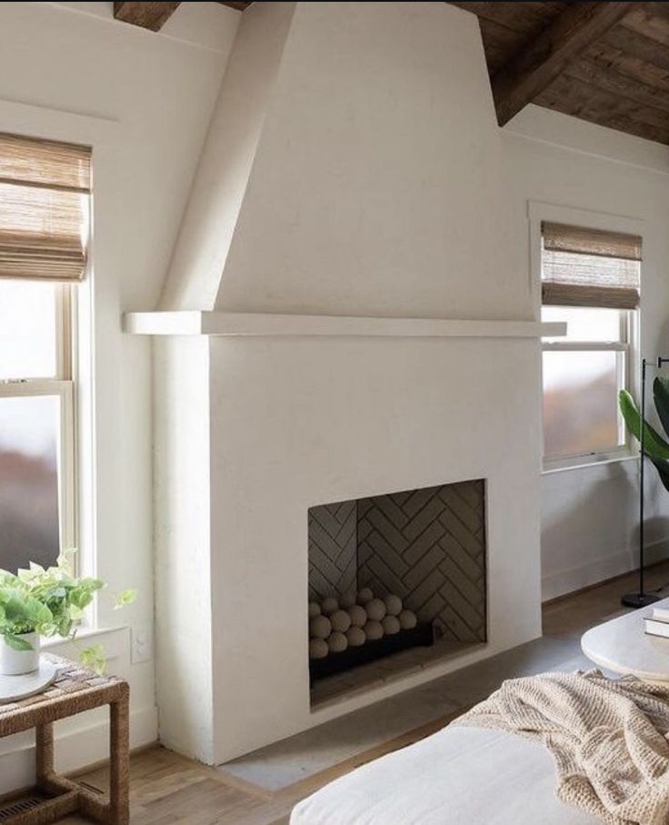 a living room with a fire place in the center and two windows on both sides