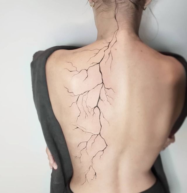 the back of a woman's neck is covered with lightning bolts