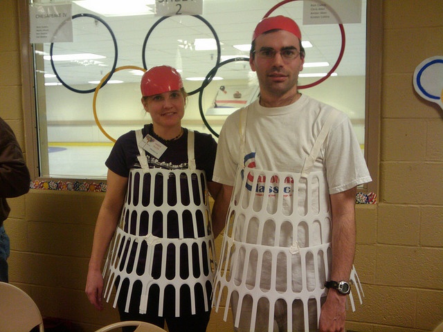 a man and woman standing next to each other in front of a table with plates on it