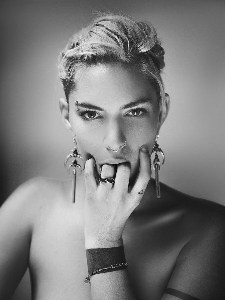 a black and white photo of a woman holding her hand to her face with both hands