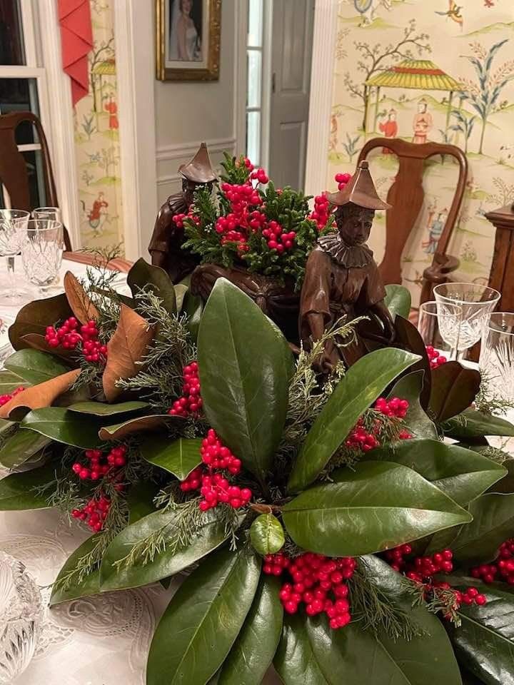 the centerpiece is decorated with red berries and greenery