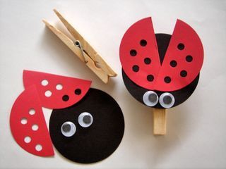 two popsicles with ladybug faces on them and clothes pins attached to them