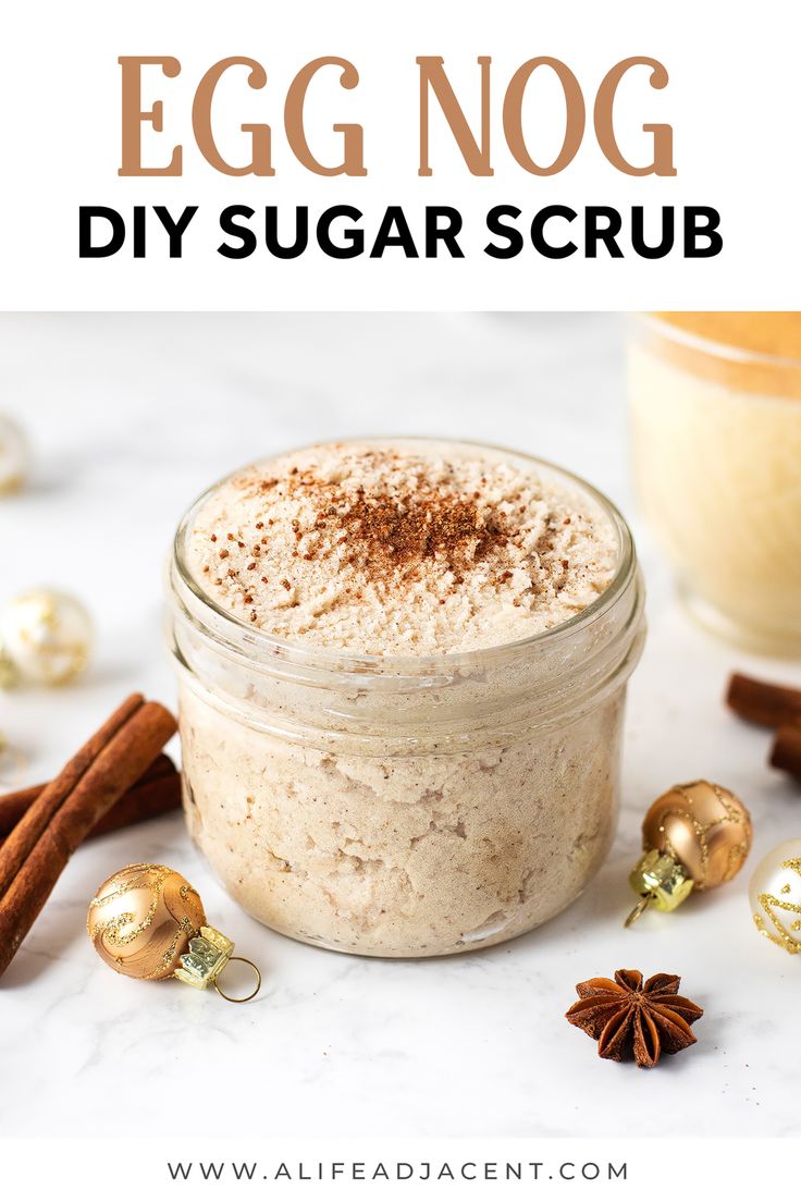 an egg nog diy sugar scrub in a glass jar with cinnamon sticks and christmas decorations around it