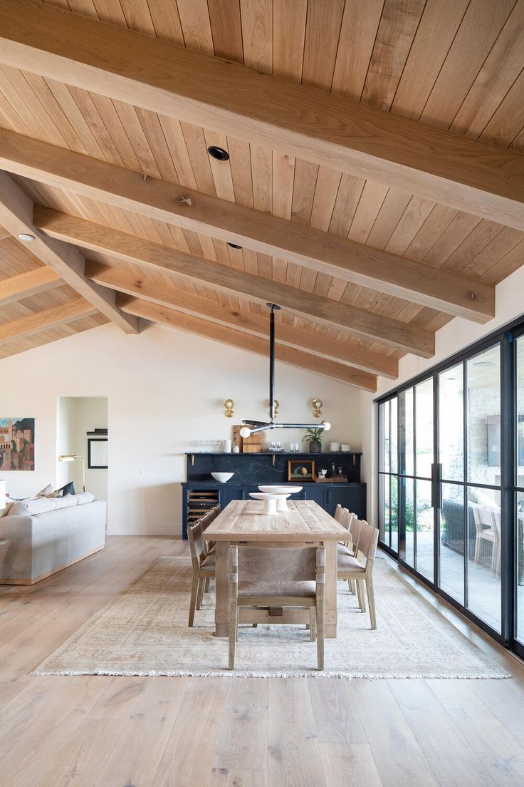 an open living room and dining area with wooden ceilings