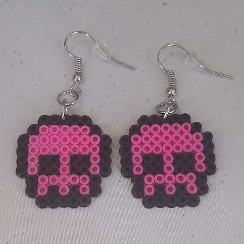 a pair of pink and black pixel earrings