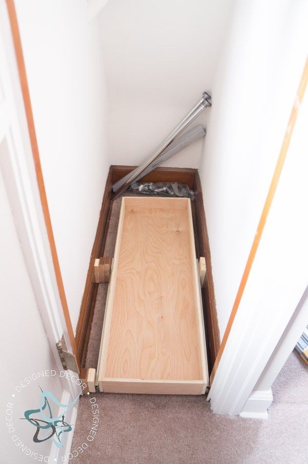 a wooden box sitting on top of a carpeted floor next to a white wall