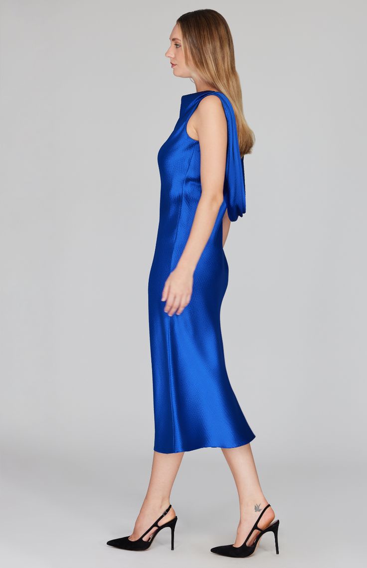 Our signature bias cut silhouette, updated with a gracefully draped front and low back detail. Cut in a flattering midi length with a clean baby hem finish. This dress is unlined and needs no closures thanks to the nature of bias cut fabric. Blue Fitted Sleek Slip Dress, Sleek Fitted Blue Slip Dress, Blue Fitted Slip Dress With Sleek Style, Blue Party Dress With Cowl Back, Elegant Blue Knee-length Slip Dress, Blue Cowl Back Dress For Party, Fitted Bias Cut Midi Dress With Cowl Back, Fitted Midi Dress With Bias Cut And Cowl Back, Fitted Bias Cut Midi Dress