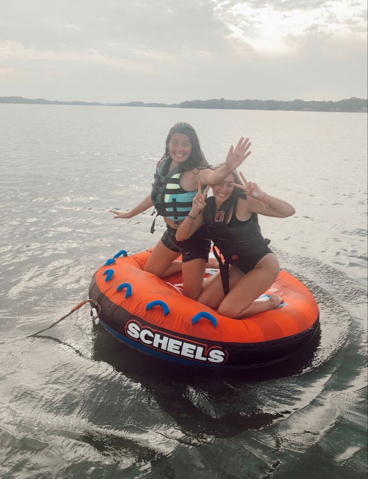 two girls on an inflatable boat waving