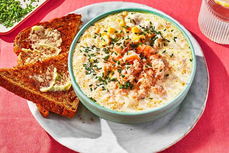 a bowl of soup on a plate with bread