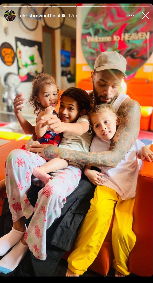 a man sitting on top of two children in front of a table with other kids