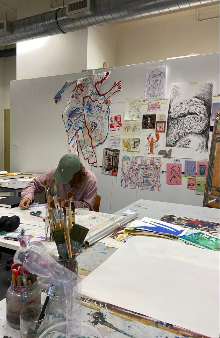 a man sitting at a table with lots of art supplies