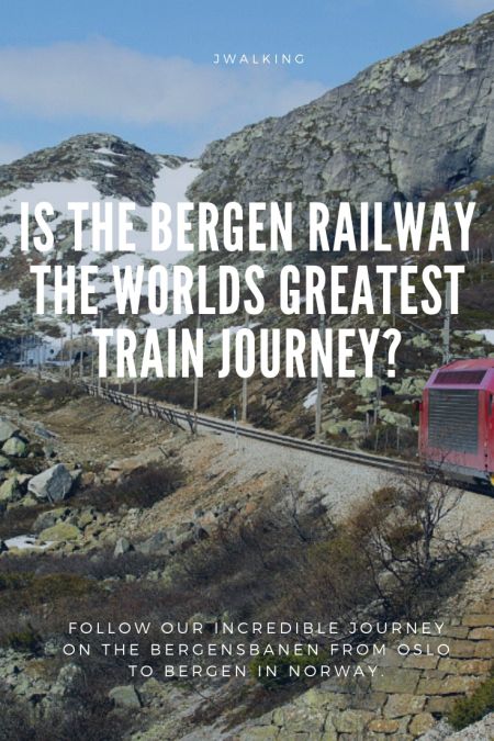 a red train traveling down tracks next to a rocky mountain side with the words, is the