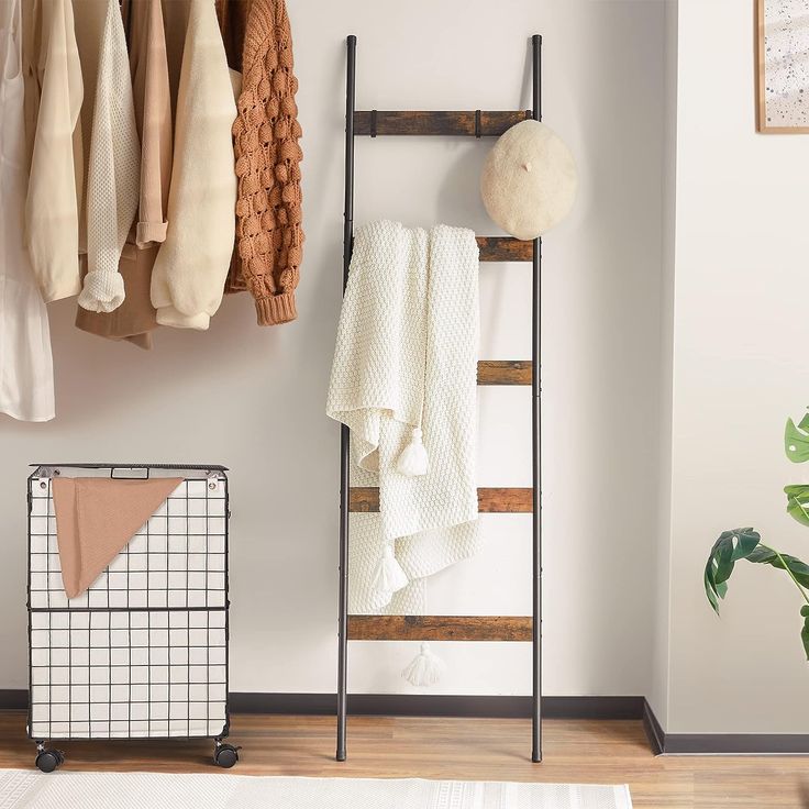 a rack with towels hanging on it next to a rug and other items in a room